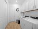Well-lit laundry room with white cabinets, modern appliances, and ample storage space at 7922 Lakes Edge Ln, Port Charlotte, FL 33981