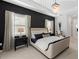 Elegant bedroom featuring tray ceiling, chandelier, patterned dark wall, and cozy seating area at 7922 Lakes Edge Ln, Port Charlotte, FL 33981