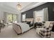 Elegant bedroom with a tray ceiling, chandelier, and luxurious furniture, next to sliding glass doors at 7922 Lakes Edge Ln, Port Charlotte, FL 33981