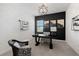 Stylish home office with black accent wall, modern lighting, and comfortable seating at 7922 Lakes Edge Ln, Port Charlotte, FL 33981