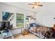 Bedroom with a bed, desk, guitar, artwork, and a large window letting in natural light at 802 Antler Ct, Brandon, FL 33511