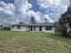 A single-story home featuring verdant lawn space, large windows, and a serene, cloud-filled sky overhead at 802 White Heron Blvd, Ruskin, FL 33570