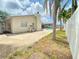 View of the backyard, featuring a swimming pool and mature trees, enclosed by a white fence at 8630 134Th St, Seminole, FL 33776