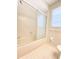 Bright bathroom featuring a bathtub with sliding glass doors and tiled flooring, creating a clean and functional space at 8630 134Th St, Seminole, FL 33776