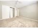 Spacious carpeted bedroom with ceiling fan, closet, and window providing ample light, enhancing the home's comfort at 8630 134Th St, Seminole, FL 33776