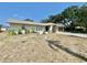 A single-story home with neutral exterior paint, green front door arch, and an unkempt front lawn at 8630 134Th St, Seminole, FL 33776