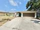 Single-story home with a two-car garage and neutral exterior paint, and a concrete driveway at 8630 134Th St, Seminole, FL 33776