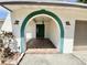 Covered front porch with brick tiling, arched door entrance, and two sconces on the sides of the door at 8630 134Th St, Seminole, FL 33776