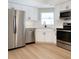 Modern kitchen with stainless steel appliances, sleek white cabinets, and wood-look flooring at 8630 134Th St, Seminole, FL 33776