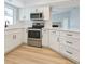 Bright kitchen with white cabinets, stainless steel appliances, and modern countertops at 8630 134Th St, Seminole, FL 33776