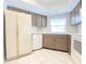 Traditional kitchen with white appliances, wood cabinetry, white tile backsplash, and tile floor at 8630 134Th St, Seminole, FL 33776