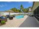 Backyard pool area featuring a lounge area, fire pit, and lush landscaping at 8630 134Th St, Seminole, FL 33776