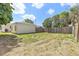 View of a spacious backyard with a wooden fence, side of house, and grassy area at 918 27Th N St, St Petersburg, FL 33713