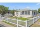 Well-maintained home featuring a white picket fence, green lawn, and cozy design at 918 27Th N St, St Petersburg, FL 33713