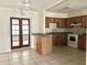 Open kitchen featuring wood cabinets, tiled floor, and a peninsula island with granite countertops at 9797 52Nd N Ter, St Petersburg, FL 33708