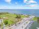 Aerial view of the waterfront community showcasing a park, long grassy field, pier, and marina under a bright sky at 1005 Main St, Safety Harbor, FL 34695