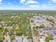 Aerial view showcases a property surrounded by lush greenery, a neighborhood, and blue sky at 1005 Main St, Safety Harbor, FL 34695
