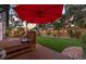 A wooden deck with a red umbrella and outdoor seating overlooking the artificial grass backyard at 1005 Main St, Safety Harbor, FL 34695