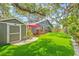 Backyard featuring a shed, deck, mature trees and manicured artificial grass at 1005 Main St, Safety Harbor, FL 34695