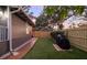 A fenced backyard features lush artificial grass and brick pavers leading to a barbeque grill at 1005 Main St, Safety Harbor, FL 34695