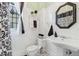 Bathroom featuring white beadboard, toilet, decorative mirror, and black and white floor tiles at 1005 Main St, Safety Harbor, FL 34695