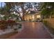 Charming home with manicured landscaping, brick driveway, and mature trees at 1005 Main St, Safety Harbor, FL 34695