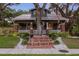 Charming two-story home featuring a brick entry, a spacious lawn, and mature trees at dusk at 1005 Main St, Safety Harbor, FL 34695