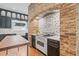 Close up view of the rustic brick work surrounding the gas cooktop and white range at 1005 Main St, Safety Harbor, FL 34695