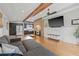 Open-concept living room with hardwood floors, beam ceilings, and exposed brick connecting to modern kitchen at 1005 Main St, Safety Harbor, FL 34695