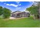 Spacious backyard showcasing the pool enclosure and well-manicured lawn, perfect for outdoor enjoyment at 10112 Downey Ln, Tampa, FL 33626