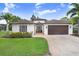 Charming single-story home with a well-manicured lawn and a two-car garage at 10112 Downey Ln, Tampa, FL 33626