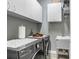 Efficient laundry room featuring modern washer and dryer, ample cabinetry, and a utility sink at 10112 Downey Ln, Tampa, FL 33626