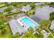 Aerial view of community pool, tennis courts, pond, and landscaped grounds at 1109 Pine Ridge W Cir # C1, Tarpon Springs, FL 34688