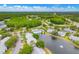 Panoramic aerial view of the community, highlighting the lakes, pool, and surrounding landscape at 1109 Pine Ridge W Cir # C1, Tarpon Springs, FL 34688