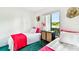 Bright bedroom features twin beds, decorative wall art, and a window view at 1109 Pine Ridge W Cir # C1, Tarpon Springs, FL 34688