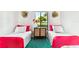 Bright bedroom features twin beds, decorative wall art, and a window view at 1109 Pine Ridge W Cir # C1, Tarpon Springs, FL 34688