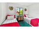 Bright bedroom features twin beds, decorative wall art, and a window view at 1109 Pine Ridge W Cir # C1, Tarpon Springs, FL 34688