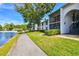 Beautifully maintained condominium exteriors with lush green landscaping and a tranquil lakeside view at 1109 Pine Ridge W Cir # C1, Tarpon Springs, FL 34688