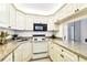 Bright kitchen featuring vintage white appliances, granite countertops, and ample cabinet space at 1109 Pine Ridge W Cir # C1, Tarpon Springs, FL 34688