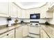 Charming kitchen features vintage white appliances, granite countertops, and ample cabinet space at 1109 Pine Ridge W Cir # C1, Tarpon Springs, FL 34688