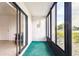 Enclosed lanai with teal carpet and large windows offering scenic water views, enhancing indoor-outdoor living at 1109 Pine Ridge W Cir # C1, Tarpon Springs, FL 34688