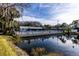 Community pool overlooking the pond, reflected in the water at 1109 Pine Ridge W Cir # C1, Tarpon Springs, FL 34688