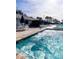 Relaxing jacuzzi with blue tiles, surrounded by lounge furniture and tropical landscaping at 1109 Pine Ridge W Cir # C1, Tarpon Springs, FL 34688
