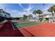 Community tennis court surrounded by green landscaping and palms at 1109 Pine Ridge W Cir # C1, Tarpon Springs, FL 34688