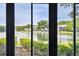 Water view with lush greenery and residential buildings, seen through a sliding glass door at 1109 Pine Ridge W Cir # C1, Tarpon Springs, FL 34688
