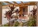Close-up of home entrance showing lush tropical landscaping and custom glasswork at 11125 117Th St, Seminole, FL 33778