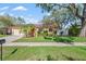 Charming single-story home featuring a lush green lawn, mature trees, and a light yellow exterior at 11125 117Th St, Seminole, FL 33778