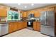 Well-lit kitchen equipped with stainless steel appliances, wood cabinets, and a large window at 11125 117Th St, Seminole, FL 33778
