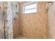 Tiled walk-in shower features a window and a handheld shower head at 11125 117Th St, Seminole, FL 33778