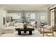 Open-concept living room with a plush sofa, kitchen view, and stylish decor, flooded with natural light at 11515 E 69Th Pl, Palmetto, FL 34221